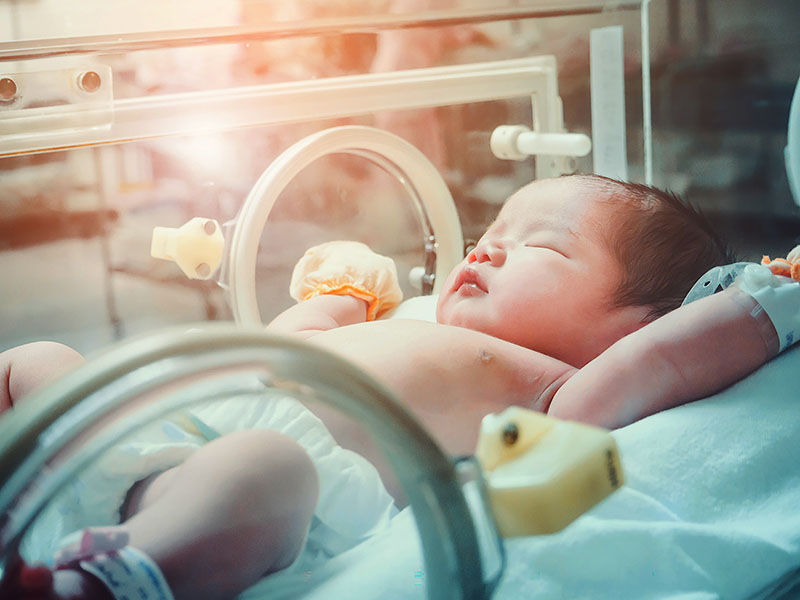 Niña recién nacida dentro de la incubadora en la sala de postparto del hospital